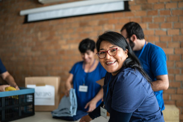 retrato de um voluntário trabalhando em um centro de doação de caridade comunitária - community center - fotografias e filmes do acervo