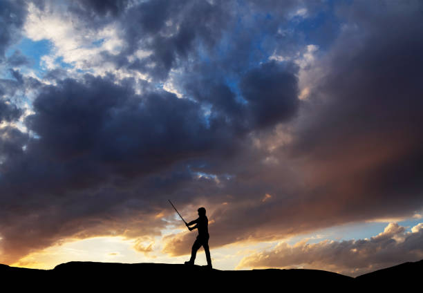 Silhouette of karate fighter on the sunset background.