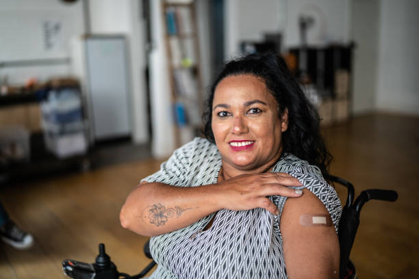 Portrait of a disabled mature woman showing  her arm after vaccination Portrait of a disabled mature woman showing  her arm after vaccination flu vaccine photos stock pictures, royalty-free photos & images