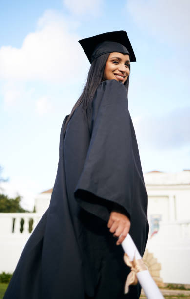 portrait of a young woman holding her diploma on graduation day - grad portrait imagens e fotografias de stock
