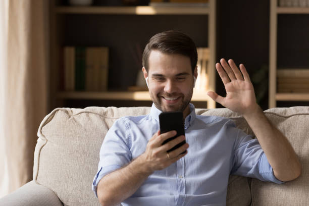 istock Happy millennial guy with wireless earphones talking on video call 1372613179