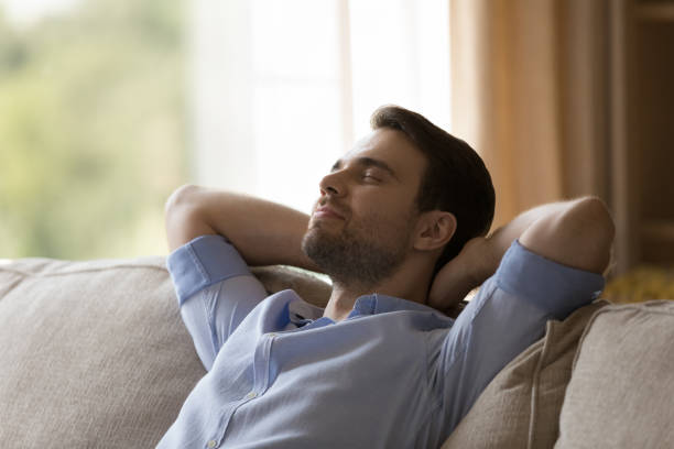 istock Happy dreamy young man relaxing at home 1372613181