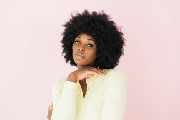 Headshot of actress standing in front of pink screen A promotional headshot of a young adult actress standing in front of a blank screen. actress headshot stock pictures, royalty-free photos & images