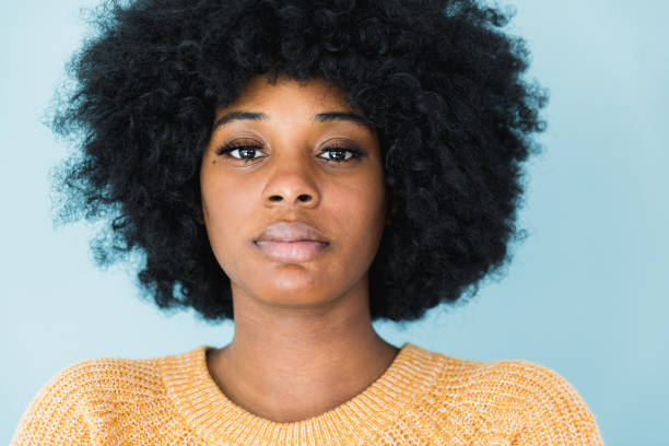 憂鬱な若い大人の女性をクローズアップ - women african descent serious human face ストックフォトと画像