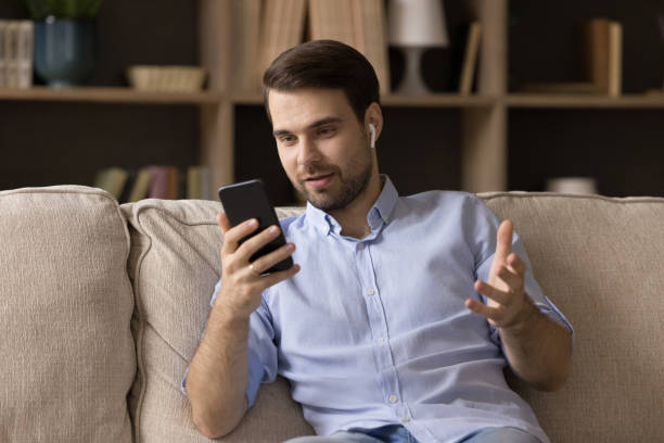 istock Positive engaged young business man using wireless earbud 1372613493