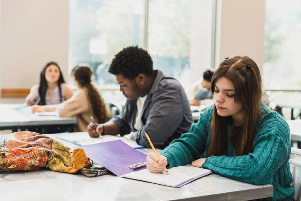 istock Teenage girl works on assignment during class 1372615083