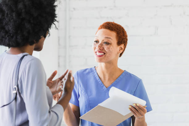 istock Smiling nurse and unrecognizable female patient discuss treatment 1372615400