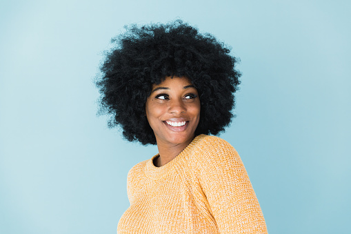 The beautiful African American woman smiles for her candid headshot photo.