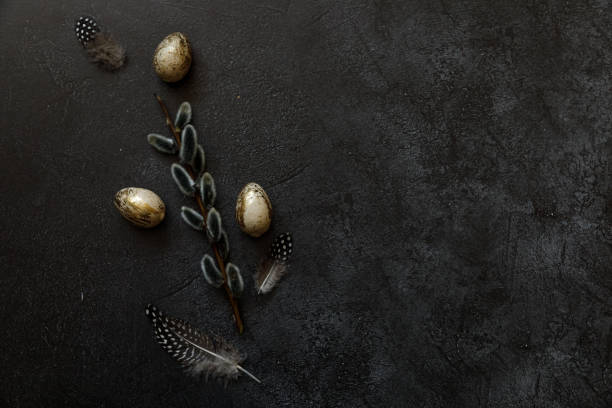 istock Happy Easter concept. Preparation for holiday. Golden decorated easter eggs willow feather on trendy grunge scratched dark black shale background. Simple minimalism flat lay top view, copy space 1372620175