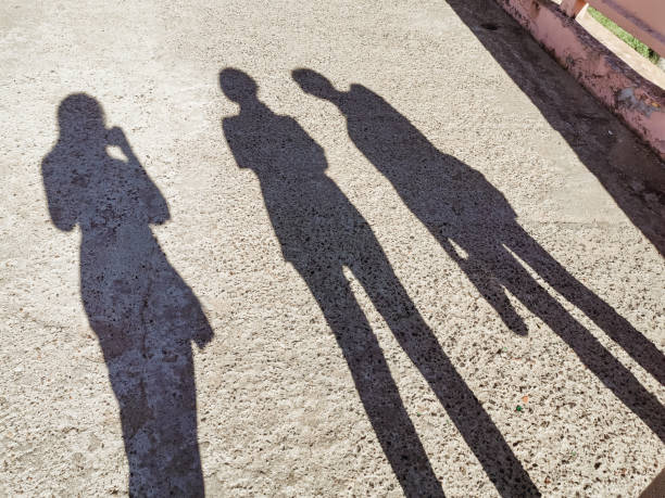 istock Shadows of people on pavement in black white 1372621232