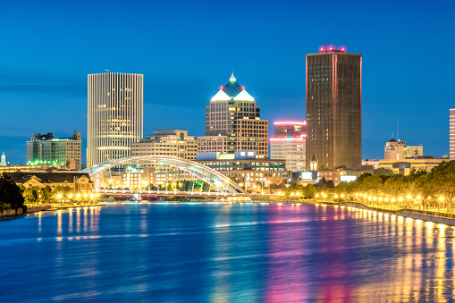 Skyline of Rochester, New York state, USA with reflections in the Genesee River at twilight blue hour.