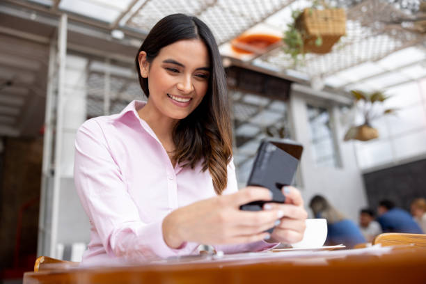 istock Happy woman using her cell phone at a restaurant 1372628014
