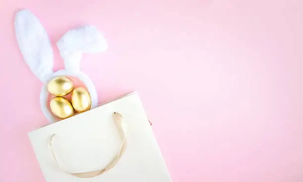 Photo of Gift bag with rabbit ears and golden Easter eggs