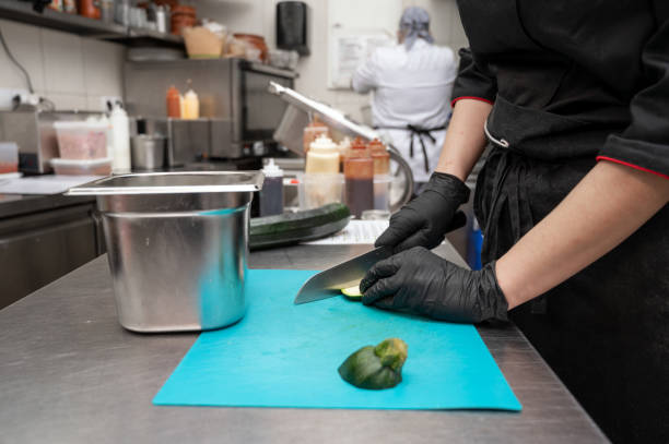 chef mulher cortando legumes em uma cozinha comercial. foto de alta qualidade - hotel commercial kitchen organic salad - fotografias e filmes do acervo