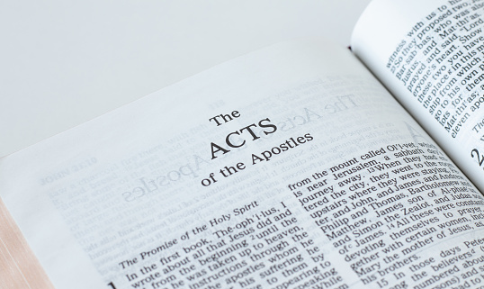 Acts of the apostles open Holy Bible Book isolated on white background. A close-up. New Testament Scripture. Studying the Word of God Jesus Christ. Christian biblical concept of faith and hope.