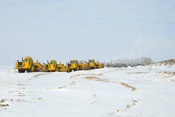 строительство тяжелое парковать в ряд - wheel tractor scraper стоковые фото и изображения