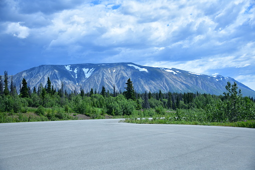 mountain range, cloudy sky, forest along Yukon highway