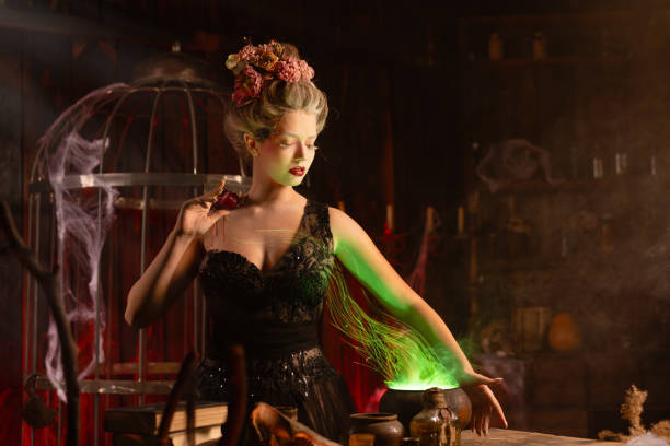 Halloween witch with cauldron. Beautiful young woman conjuring, making witchcraft. Standing spooky dungeon dark room. Enchantress prepare love potion use magic spell