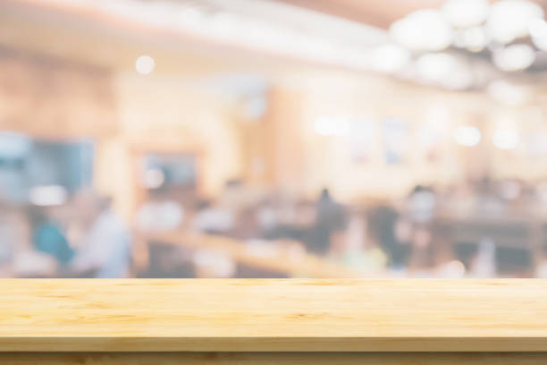istock Empty wood table top with cafe restaurant interior blurred background 1372638093