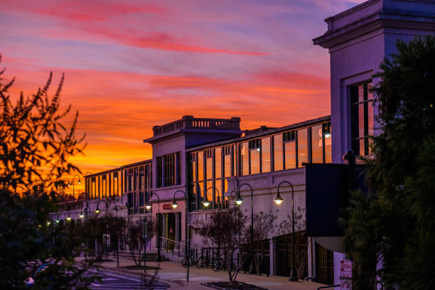 A small train station seen at sunset with vibrant colors in the sky and reflected from the windows