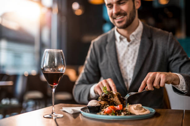 istock Happy young man eating lunch at a restaurant. 1372643980