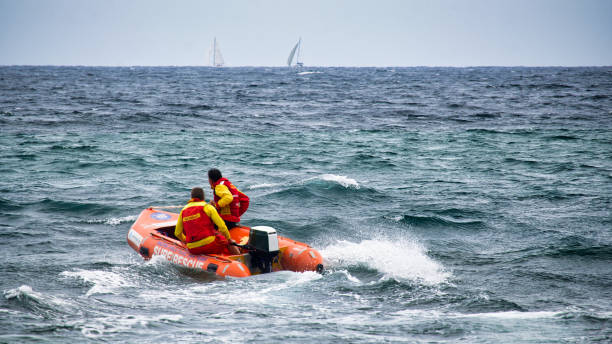 mona vale beach lifesavers si dirige verso il mare nella loro barca - surfing new south wales beach australia foto e immagini stock