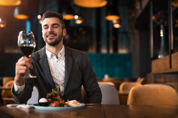 istock Happy young man eating lunch at a restaurant. 1372644721
