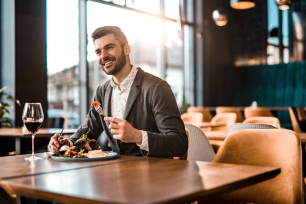 istock Happy young man eating lunch at a restaurant. 1372644751