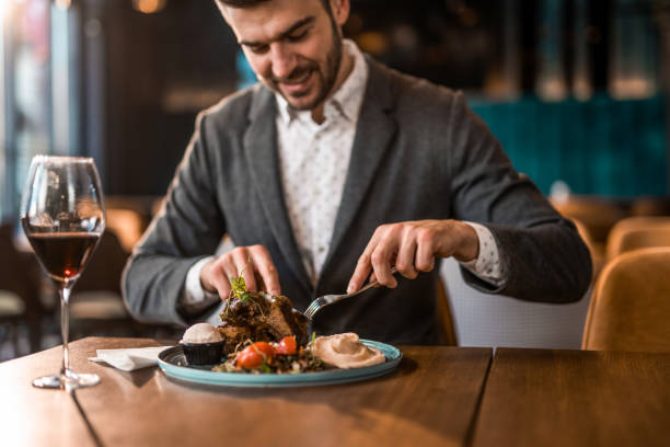 istock Happy young man eating lunch at a restaurant. 1372644787