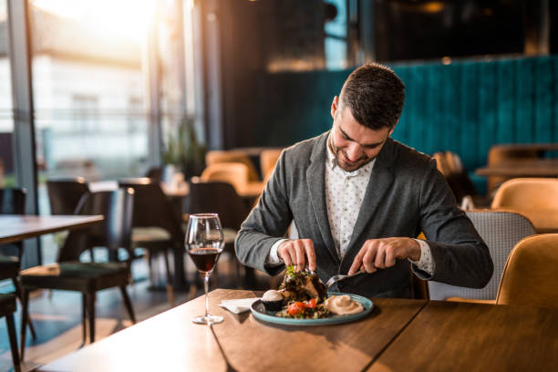 istock Happy young man eating lunch at a restaurant. 1372644810