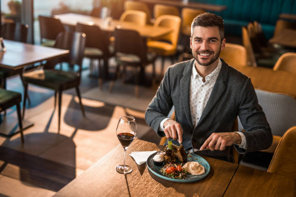 istock Happy young man eating lunch at a restaurant. 1372645370