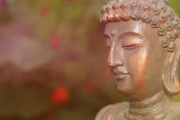 istock Buddha Statue in Garden with blurred flowers in background 1372654942