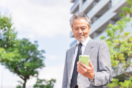 senior asian businessman who see a smart phone