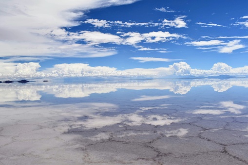 Salar de Uyuni of Bolivia is the largest salt lake in the world. The sky reflected on the water of the salt hexagon ground are stick together at horizon.