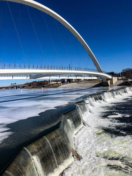 White single arch pedestrian bridge with waterfalls