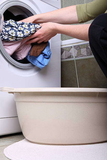 istock woman loading the washing machine in bathroom 137266334