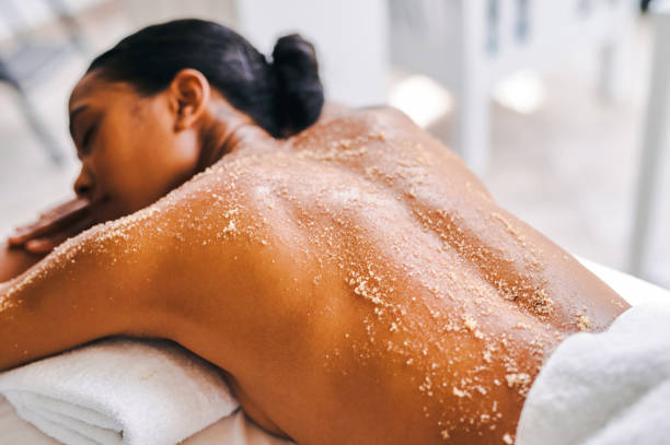 foto de una atractiva joven recibiendo un masaje exfoliante en un spa - exfoliacion fotografías e imágenes de stock