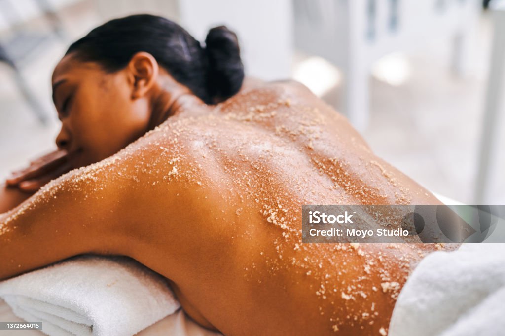 Shot of an attractive young woman getting an exfoliating massage at a spa Come for the skin treatment, stay for the experience Exfoliation Stock Photo