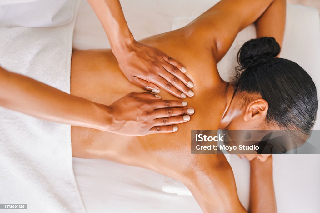 Shot of an attractive young woman getting a massage at a spa Get back to zen again Massaging Stock Photo