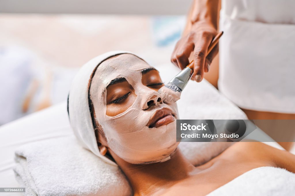 Shot of an attractive young woman getting a facial at a beauty spa Lay back and let her work her magic Facial Mask - Beauty Product Stock Photo