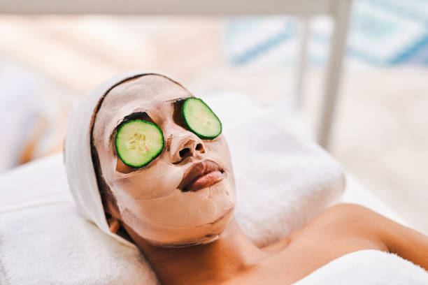 photo d’une jeune femme séduisante se faisant faire un soin du visage dans un spa de beauté - cucumber facial mask human face women photos et images de collection