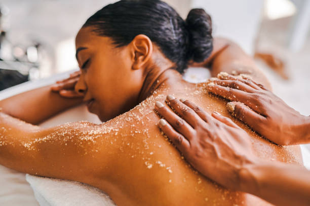 foto de una atractiva joven recibiendo un masaje exfoliante en un spa - exfoliacion fotografías e imágenes de stock