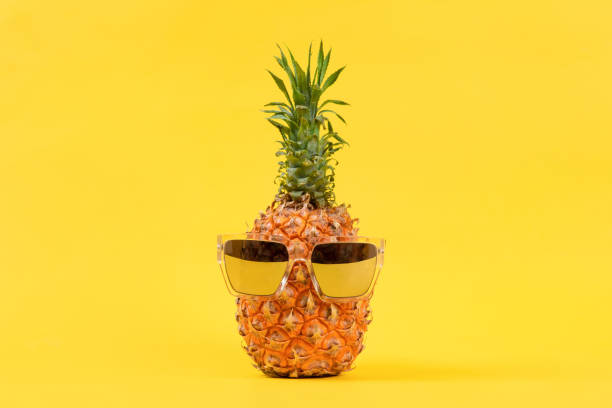 istock Ripe pineapple with sunglasses on yellow background 1372677203