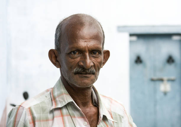 Poor Indian man standing on a street and asking for support.
