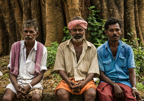 Kochi (Kerala), India: Three men sitting in a park in downtown Kochi.