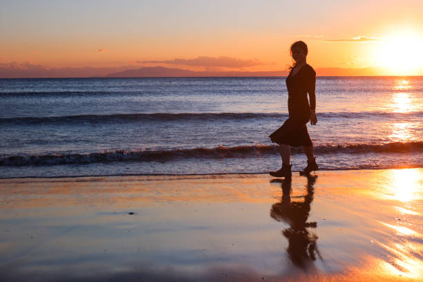 istock Beautiful young woman relaxing at sunset beach 1372678898