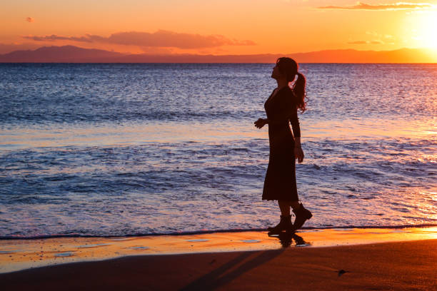 istock Beautiful young woman relaxing at sunset beach 1372679088