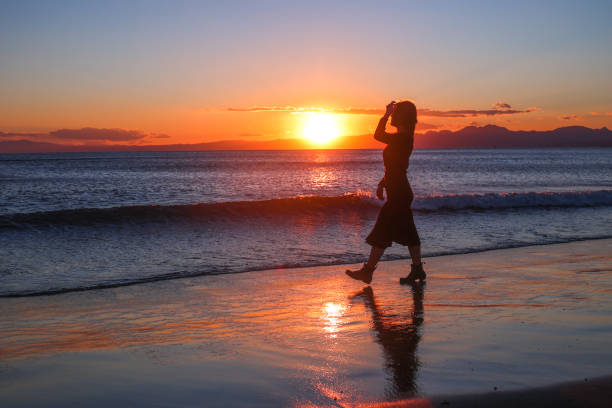 istock Beautiful young woman relaxing at sunset beach 1372681787