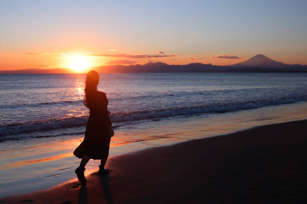 istock Beautiful young woman relaxing at sunset beach 1372683032