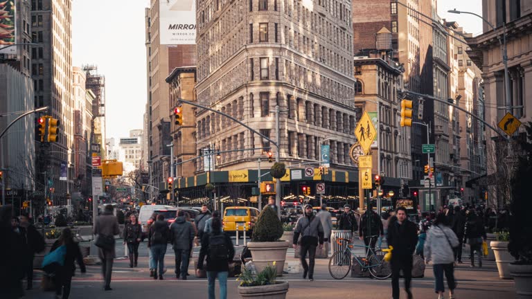 Flatiron Building with pedestrians and traffic road intersection, Manhattan, New York City, United States